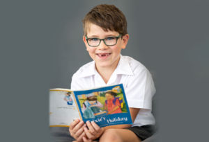 A primary school boy reads a book